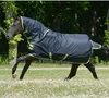 A dark horse wearing a dark blue turnout blanket with lime green trim is trotting in a grassy field with trees in the background. Produktbild-Vorschau