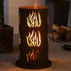 A portable fire pit with flame cutouts is shown outdoors on a patio. Produktbild-Vorschau