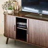 A TV cabinet with sliding doors, a television, and decorative items on top. Anteprima dell’immagine prodotto