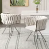 Two dining chairs with braided upholstery and silver legs are placed on a patterned rug in front of a white dining table. Produktbild-Vorschau