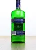 A green glass bottle of Becherovka liqueur stands upright on a wooden surface against a white background. Produktbild-Vorschau