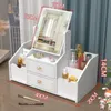 A white makeup organizer with a mirror, filled with various cosmetic products. Náhled obrázku produktu