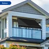 A black awning is extended over a balcony of a modern house. Náhľad obrázku produktu
