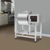 A stainless steel meat mixer/marinator machine is shown in a studio setting with a blurred kitchen background. Podgląd zdjęcia produktu