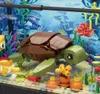 A detailed close-up of a LEGO-style aquarium build, featuring a sea turtle, clownfish, and various coral and plant elements. Náhľad obrázku produktu