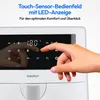 A close-up of a white air fryer's touch control panel with a hand interacting with it. Text overlays describe the features. Produktbild-Vorschau
