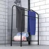 A black metal towel rack with several towels on it, placed in a bathroom with white tiled walls. Voir les images du produit