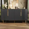 A dark gray sideboard with geometric patterns, gold handles, and gold legs, placed in a room with a painting, a lamp, and curtains.