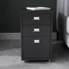 A dark gray filing cabinet with three drawers sits on a gray marble floor. Podgląd zdjęcia produktu