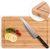 A bamboo cutting board with a knife, lemons, tomatoes, and parsley. Náhled obrázku produktu