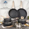 A collection of cookware with granite-like exteriors and wooden handles, displayed against a marble-patterned background. Podgląd zdjęcia produktu