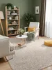 A cozy living room scene with a bookshelf, armchair, and rug. Voir les images du produit