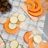 Sliced fruits and vegetables are arranged on a checkered cloth, with some items in a glass container and others on a wooden cutting board. Náhľad obrázku produktu