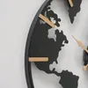 A close-up of a black metal wall clock with a world map design and gold hour markers. Podgląd zdjęcia produktu