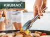 People are grilling outdoors with a hand holding tongs over a grill. Náhled obrázku produktu