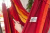 A close-up of a person's hand touching a colorful hammock. Náhled obrázku produktu
