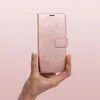 A hand holding a rose gold mandala-patterned phone case. Produktbild-Vorschau