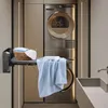 A wall-mounted ironing board with laundry items in a modern laundry room setting. Produktbild-Vorschau