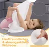 A baby playing with a white cloth on a gray sofa. Anteprima dell’immagine prodotto