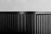 A close-up shot of the fluted front of a black cabinet. Produktbild-Vorschau