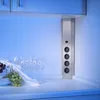 A pop-up power outlet on a kitchen counter with wine glasses and fruit. Produktbild-Vorschau