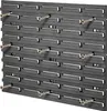 A close-up view of a black plastic workshop wall organizer with several screws inserted into it. Produktbild-Vorschau