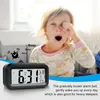 A child yawning in bed with an alarm clock in the foreground. Anteprima dell’immagine prodotto