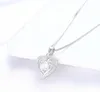 A silver heart-shaped pendant necklace with a clear stone, resting on a white surface. Anteprima dell’immagine prodotto