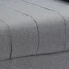 A close-up view of the textured gray fabric of a sofa or chair, showing the stitched seams that create a tufted or channel effect. Produktbild-Vorschau