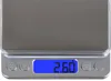 A close-up view of a digital scale with a blue display showing a weight reading. Produktbild-Vorschau