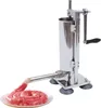 A stainless steel sausage stuffer with a crank handle is shown, with raw sausage meat being extruded into a coil on a plate. Náhled obrázku produktu