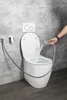 A person is using a bidet spray attachment to rinse a toilet bowl. Náhled obrázku produktu
