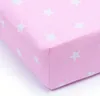A close-up, angled view of a pink fitted sheet with white stars, isolated on a white background. Produktbild-Vorschau