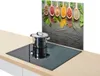 A pot sits on a black induction stovetop with a decorative backsplash featuring spices in spoons. Podgląd zdjęcia produktu
