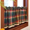A close-up view of plaid curtains with lace trim hanging in a window. Náhled obrázku produktu