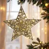 A decorative star with lights hanging in front of a window, with Christmas tree branches in the foreground and background. Anteprima dell’immagine prodotto