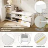 A white shoe bench with storage compartments and drawers, shown in a room setting with some decorative items. Produktbild-Vorschau