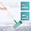 A hand holding a snow shovel with a green metal head and a wooden handle, clearing snow or ice from a surface. There are two informational icons in the upper right corner. Produktbild-Vorschau