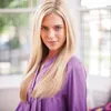 A woman with blonde hair wearing a purple shirt is looking at the camera. Podgląd zdjęcia produktu