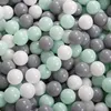 A close-up view of many small, round balls in various shades of gray, white, and mint green, tightly packed together. Anteprima dell’immagine prodotto