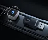 Two electronic devices, a square and a USB stick, are placed on a dark, glossy surface, possibly a car's interior console. Anteprima dell’immagine prodotto