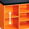 A close-up view of an orange shoe cabinet with a black cushion on top, showing its internal compartments and an arrow indicating adjustable shelf height. Produktbild-Vorschau