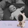 A baby lying in a crib next to a baby monitor. Produktbild-Vorschau