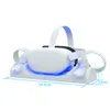 A white Oculus Quest 2 docking station with blue LED lights, holding the VR headset and controllers. Produktbild-Vorschau