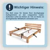 An instructional image showing a wooden bed frame with arrows pointing to specific areas, accompanied by text providing important information. Produktbild-Vorschau