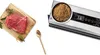 A raw cut of beef on a wooden cutting board next to a vacuum sealer with dried herbs and spices. Anteprima dell’immagine prodotto