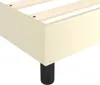 A close-up view of the corner of a cream-colored boxspring bed frame with a black leg. Náhled obrázku produktu