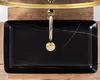 A top-down view of a black rectangular sink with gold faucet. Produktbild-Vorschau