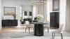 A dining room with a round dining table and chairs, a credenza, and a display cabinet. Produktbild-Vorschau