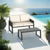 A patio set with a sofa and coffee table next to a swimming pool with the ocean in the background. Voir les images du produit